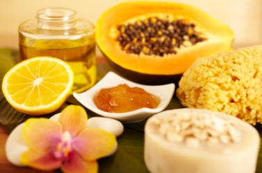 Spa still life of organic skincare, honey, papaya, lemon and massage oil, oatmeal, orchid flower, bar of soap and bath sponge